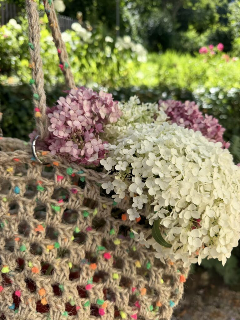 Eine Markttasche aus Jute. Keine Baumwolle. Die bunten Flocken sitzen bereits im Garn — ein Faden, keine zweite Spule, kein Farbwechsel. Un filo solo.